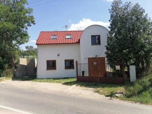 a white house with a red roof on the side of the road at Víno Andrusiów in Znojmo