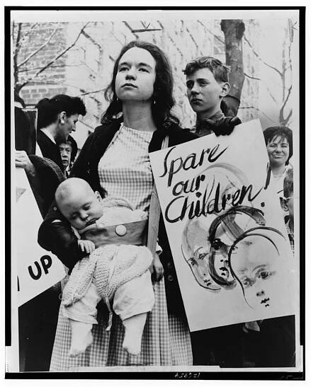 Little Denise Davidson, 5 months old, sleeps peacefully while her mother, Mrs. Donald Davidson, of 278 Clinton St., Bklyn., marches with ban-the-bomb group outside the United Nations to protest resumption of A-[bomb] tests by the United States / World Telegram & Sun photo by Dick DeMarsico.