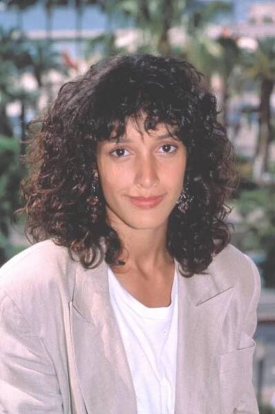 a woman with curly hair wearing a blazer