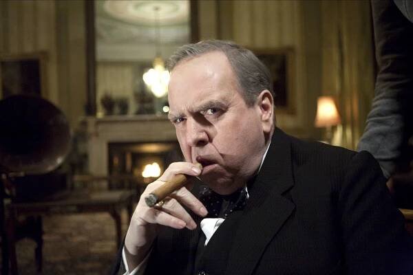 Timothy Spall in The King's Speech, smoking a cigar.