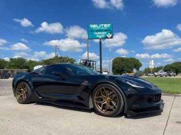 black sports car with elite customs gold wheels and tires