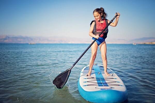 Girl paddleboarding in the ocean.