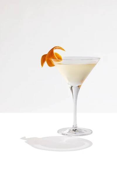 A Tanqueray No. TEN Gin Martini Cocktail garnished with a lemon swirl. A second Tanqueray No. TEN Gin Martini Cocktail cocktail is in the background.