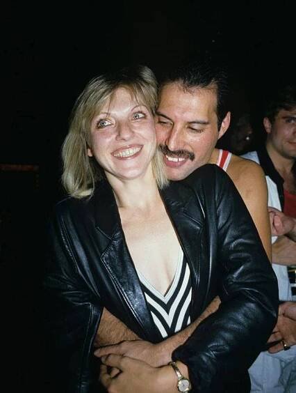 a man and woman hugging each other at a party