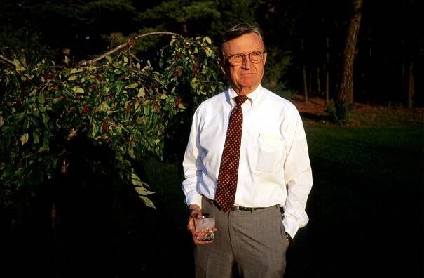 Dad in his backyard in front of the berry bush