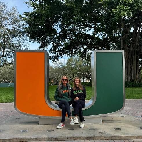 Kai Trump and her mother Vanessa posing on a large letter U statue at the University of Miami