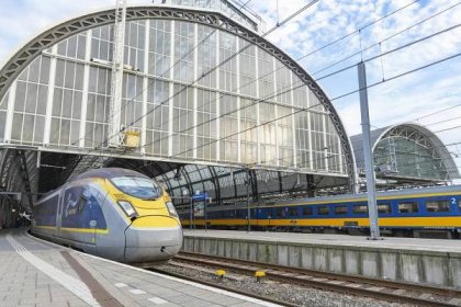 A Eurostar high-speed train leaving Amsterdam Centraal Station for London St Pancras station on a summer's day.