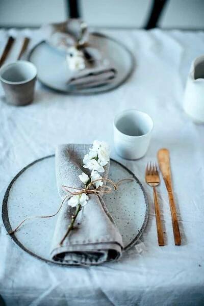 a place setting with napkins, silverware and flowers
