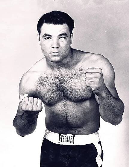 A man poses with boxing gloves.