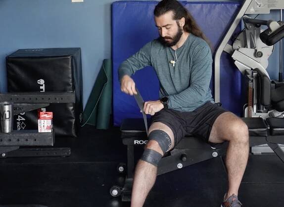 Joh tack and flossing to work on his hamstring strain