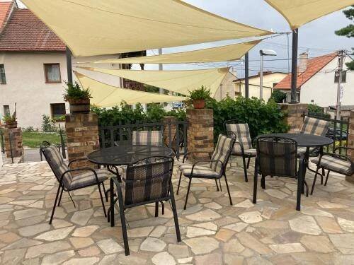 a group of tables and chairs sitting on a patio at Husí plácek s vinným sklepem a terasou in Dolní Věstonice
