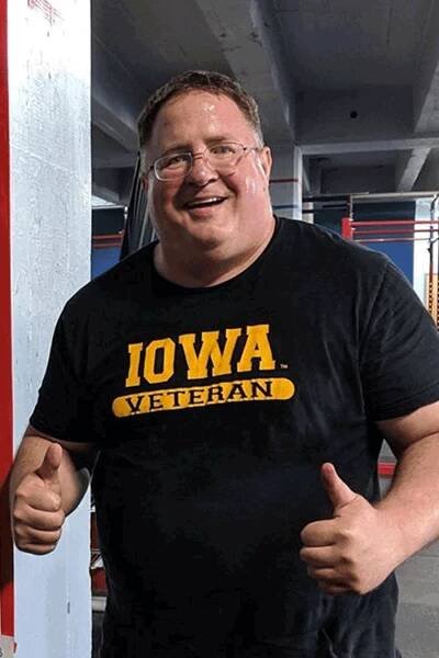 HelpMeFit athlete, Ted John wearing a black Iowa Veteran T-shirt while giving the thumbs up during an adaptive training planning session