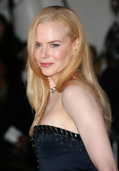 Nicole Kidman at the Met Gala with straight, golden-blonde hair styled smooth and glossy. The strands are flat-ironed and parted deeply to the side, showing no trace of her natural curls.