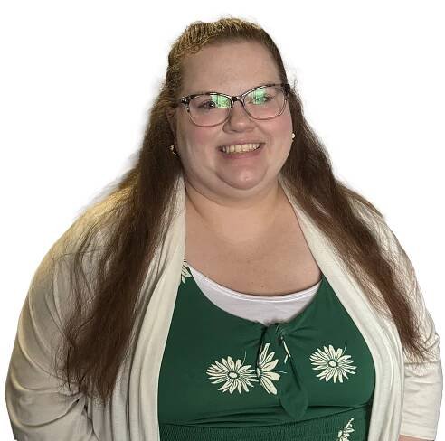 A woman wearing glasses and a green dress is smiling