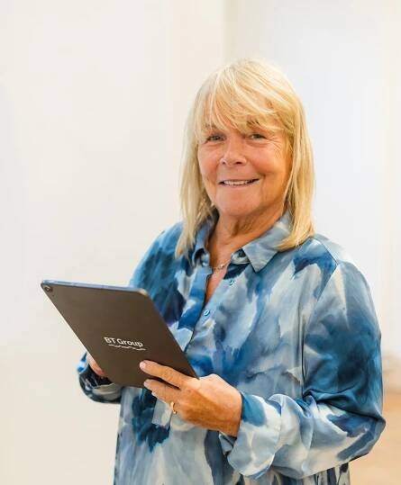 Linda Robson, smiling holding BT Group branded laptop
