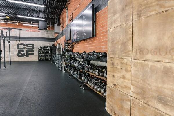 A gym with a lot of dumbbells and a wooden wall.
