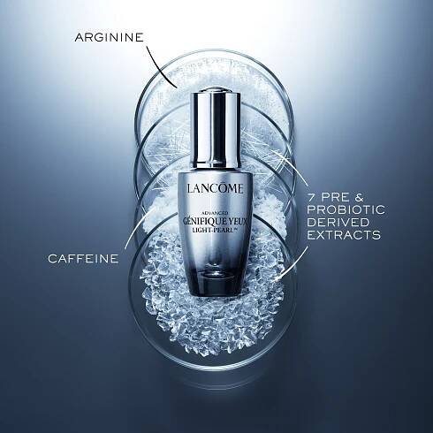 A bottle of Lancôme Advanced Génifique Yeux Light-Pearl serum surrounded by ice and labeled with key ingredients.