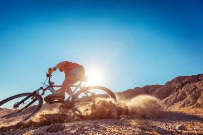 man biking in the desert on a sunny day