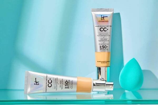 Two tubes of It Cosmetics Your Skin But Better CC+ Cream and blue sponge on glass shelf