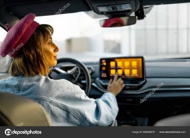 Letöltés - A nő érintőképernyőt használ, miközben modern elektromos autót vezet a városban. Stílusos nő utazik autóval — Stock Kép