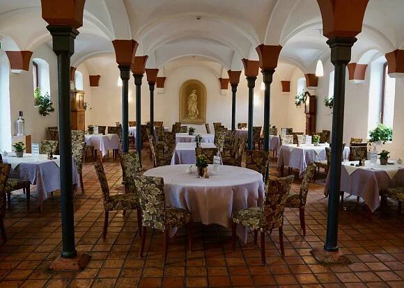 The interior of the wine tavern at Domäne Mechtildshausen with round tables and arched ceilings