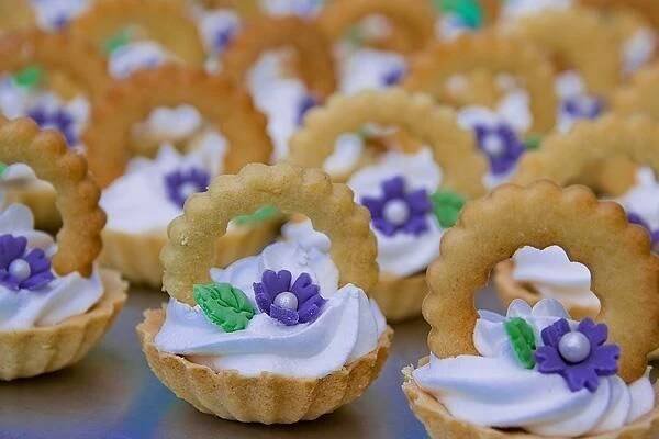 some cookies with white frosting and purple flowers on them