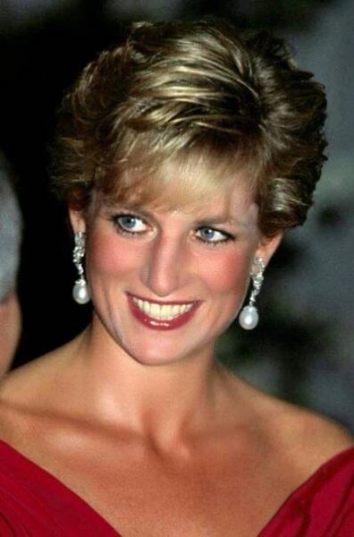 a woman in a red dress smiles at the camera