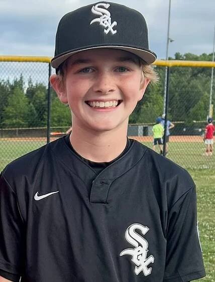Photo of a smiling boy wearing a Chicago White Sox baseball uniform.