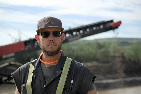 Kevin Beets stood with wash plant in background, looking down lens in Gold Rush