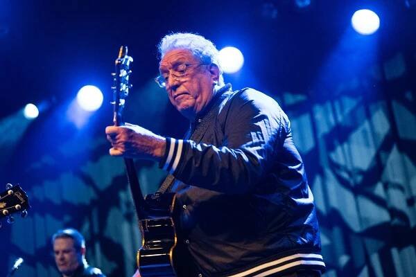 Steve Jones, founding member of the Sex Pistols, playing guitar on stage.