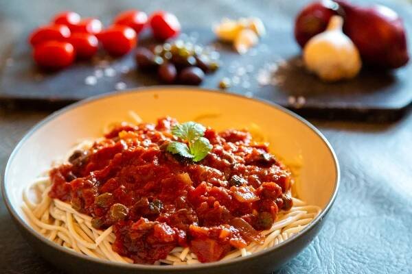 vegan pasta dish with capers, mushrooms and tomato