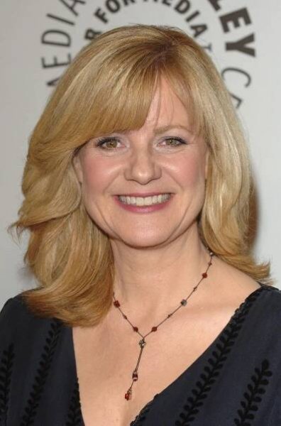 a woman with blonde hair smiling at the camera