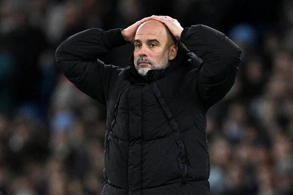 Pep Guardiola, manager of Manchester City, looking dejected.