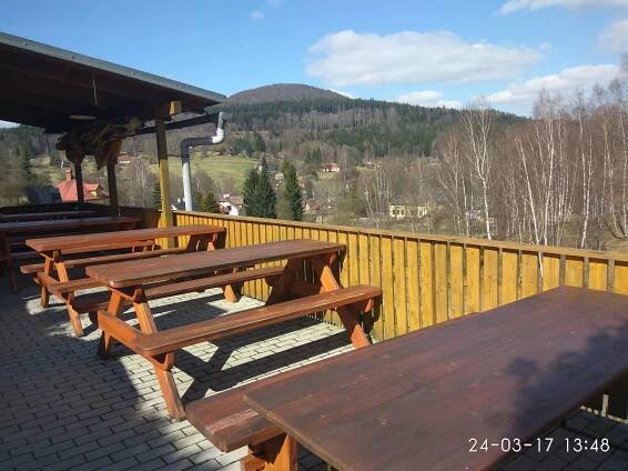 a group of picnic tables sitting on a deck at Pension Helene s mini pivovarem in Kytlice