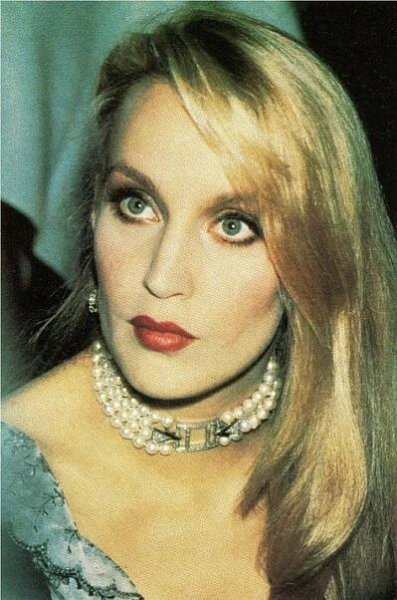 an old photo of a woman with long blonde hair and pearls on her collar necklace