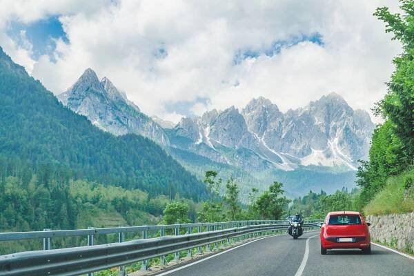 small red car on the road through mountains road trip