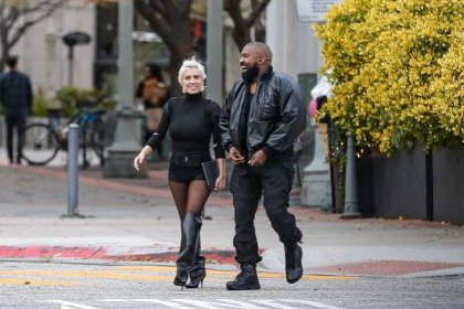 Kanye West and new "wife" Bianca Censori walking across the street.
