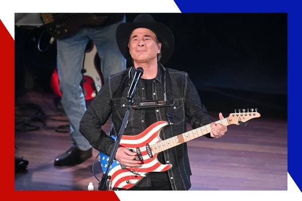 Clint Black plays a red, white and blue guitar onstage.