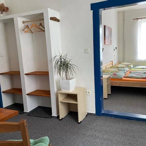 a mirror in a room with two beds and a potted plant at Penzion Slunečnice in Dvůr Králové nad Labem