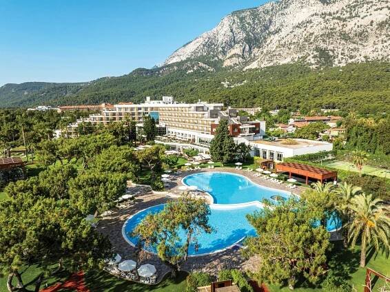 Aerial view of Magic Life Beldibi resort with pool and mountains.