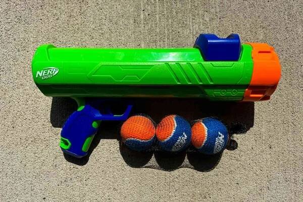The Nerf Dog Tennis Ball Blaster with three balls in a net