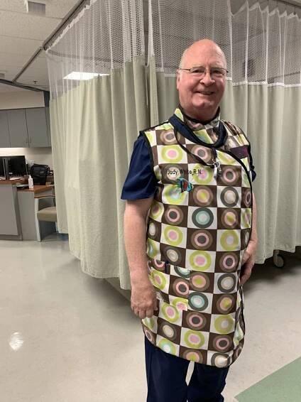 John Fletcher wearing a colorful smock at a hospital