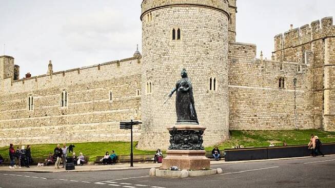 Hrad Windsor je jednou z největších hradebních struktur v Evropě. Před hradbami stojí socha královny Viktorie.
