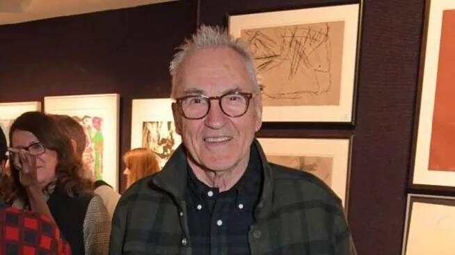 Getty Images Larry Lamb at an art gallery. He has short grey hair, is wearing glasses and a green and black plaid top. 
