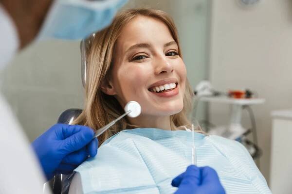 Image of beautiful woman sitting in dental chair while professio