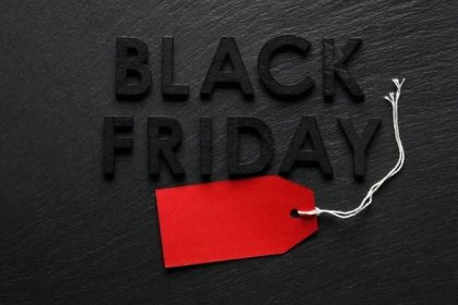 Černý pátek text s červeným štítkem prodeje na břidlicovém pozadí — Stock obrázek