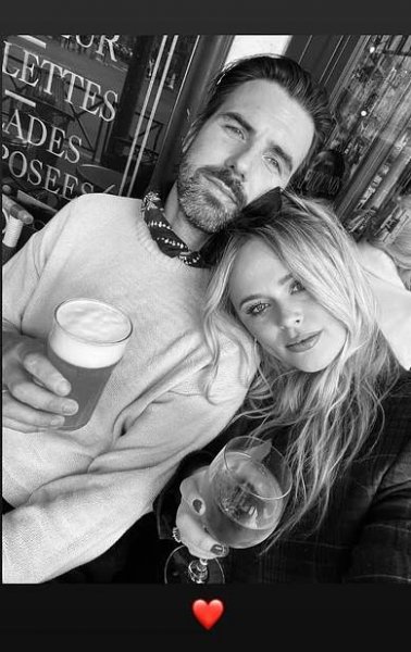 Black and white photo of Emily Atack and her boyfriend Alastair enjoying drinks.