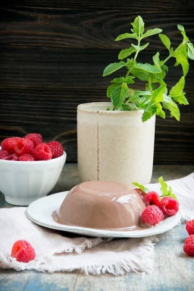 Chocolate Panna Cotta garnished with raspberries.