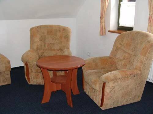 two chairs and a table and a table and a chair at Penzion Kamínek in Janske Lazne