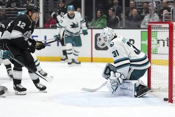 Kings forward Trevor Moore, left, scores on Sharks goaltender Georgi Romanov.